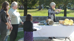 Pastor Ann, far right, and Betty Allen, (in green) tell about some of the items in the time capsule. 